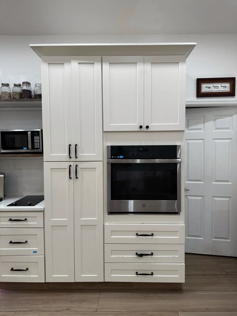 Tall white pantry cabinets with a built-in wall oven