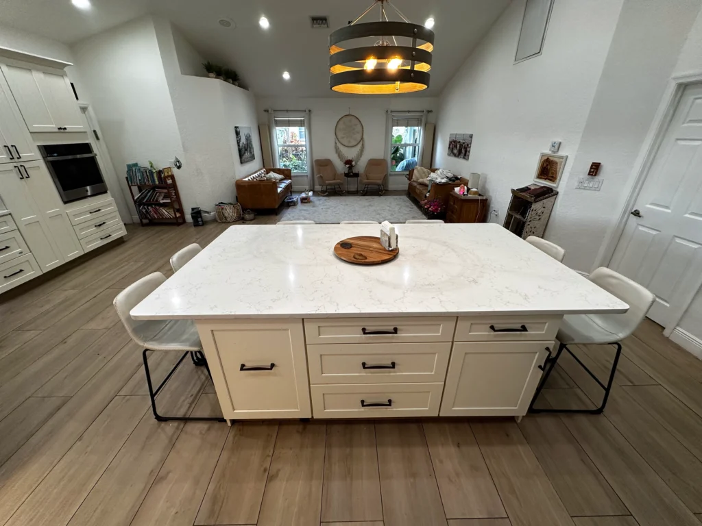 Large quartz island seen from the living area, with pendant light above