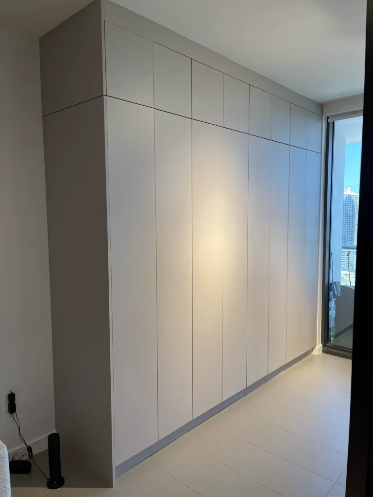 Side view of a wall-length built-in closet running to a floor-to-ceiling window