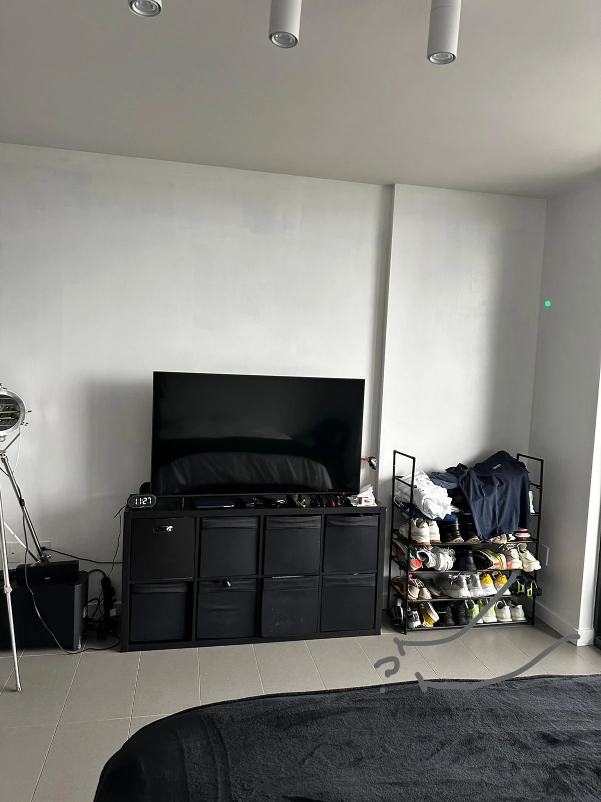 The same wall before the built-in closet, with a TV stand and an open shoe rack