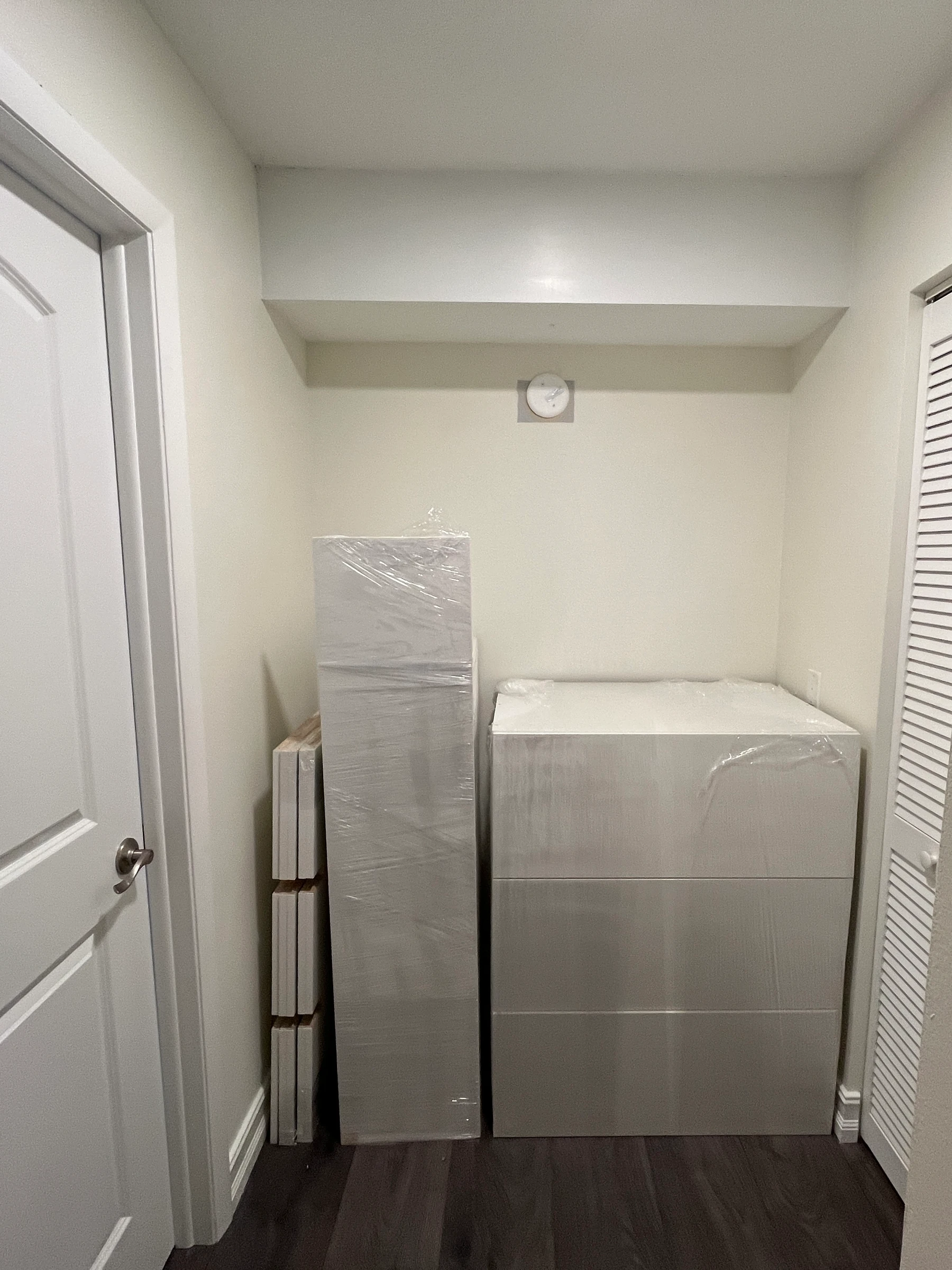 The same alcove before the closet, empty except for the delivered cabinet boxes