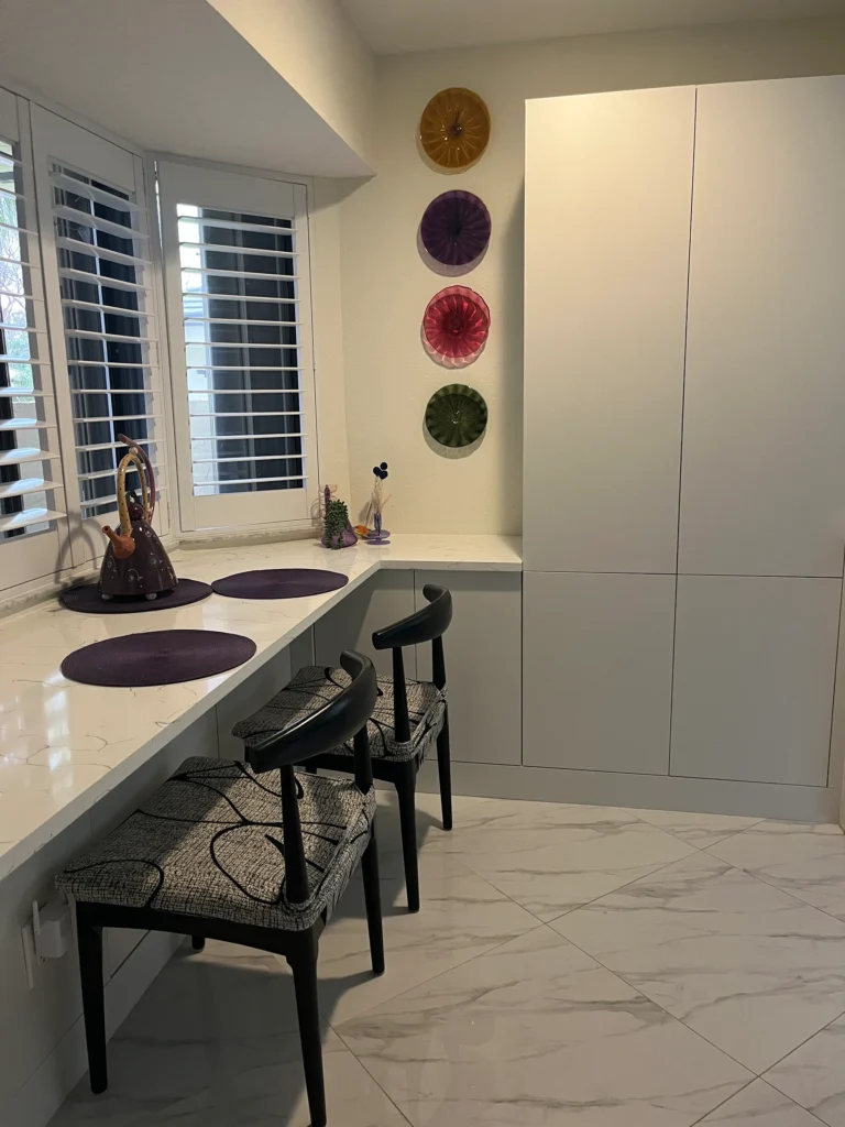 Kitchen extension with a quartz desk counter under a window and a tall white pantry cabinet