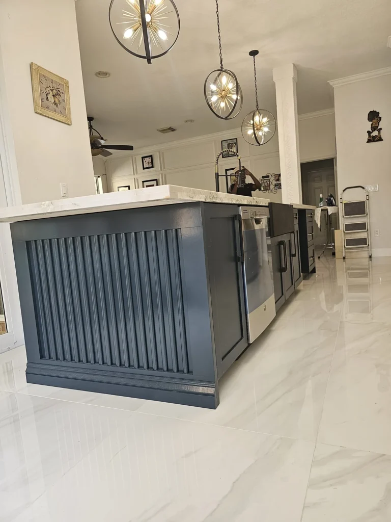 Navy beadboard kitchen island with a white marble-look top