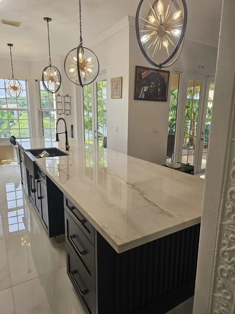 Long kitchen island with sputnik pendants and a view to the windows