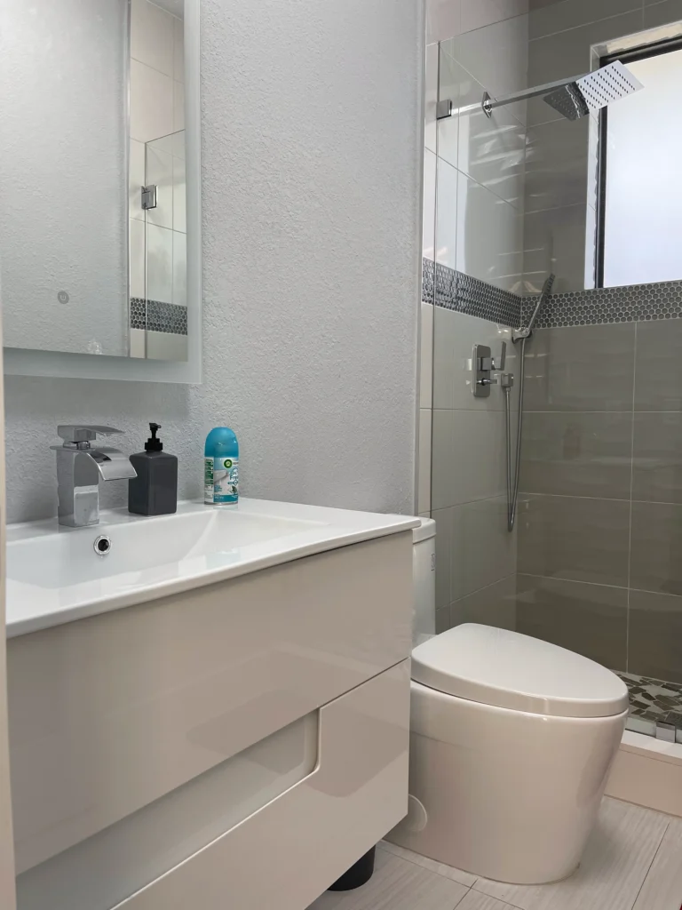 Floating vanity with a white integrated sink and backlit mirror