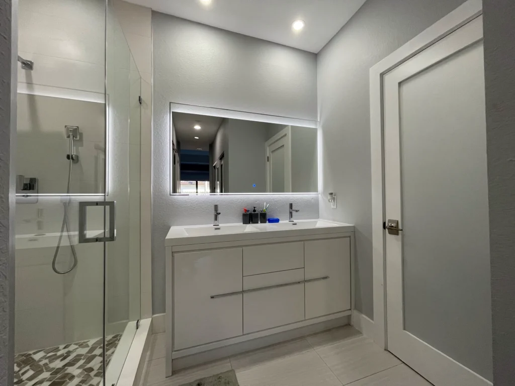 Master bathroom with glass shower, double vanity and LED mirror