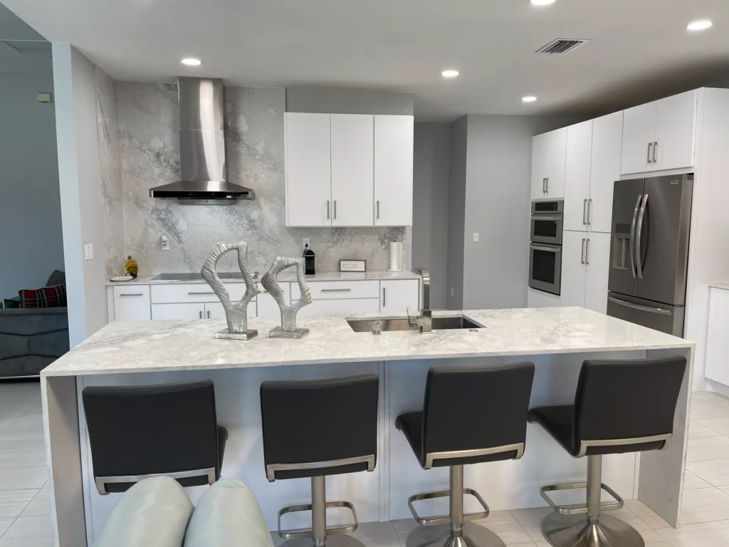 Waterfall island with seating for four in front of a white kitchen