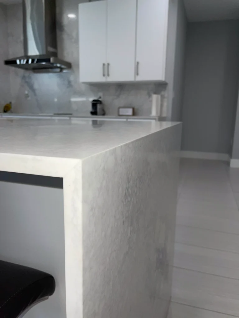Close-up of a marble-look quartz waterfall edge