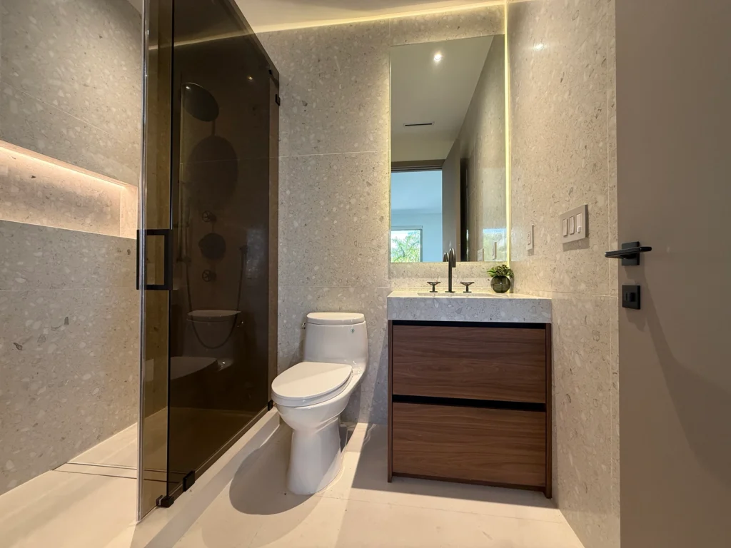 Terrazzo bathroom with a smoked-glass shower, toilet and walnut vanity