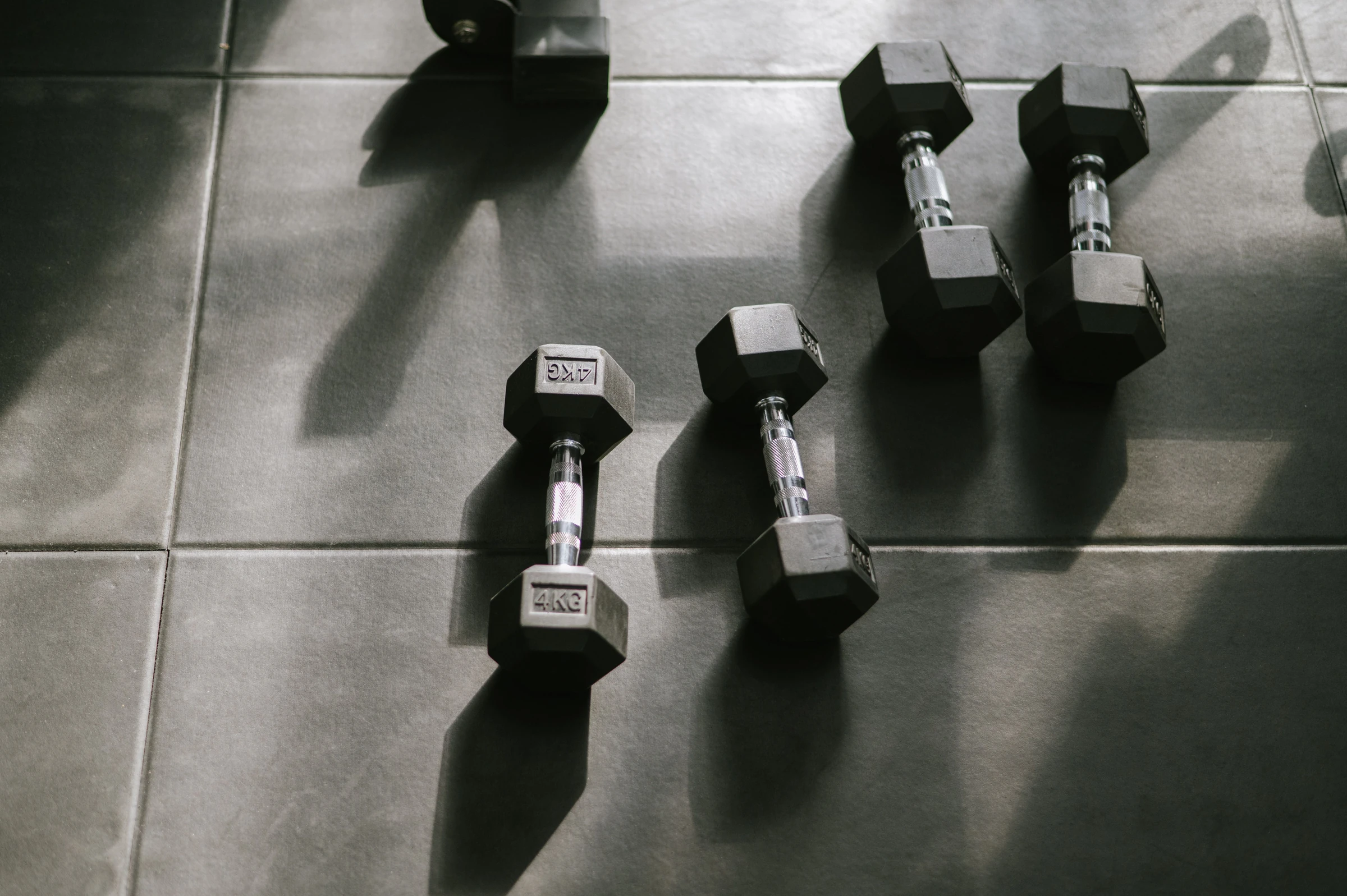 Hex dumbbells on a dark rubber gym floor