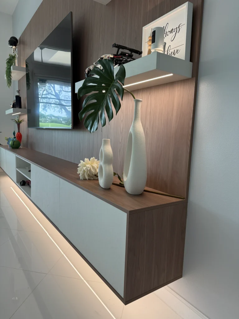 Close angle of the floating walnut-and-white console with a strip of light along the floor