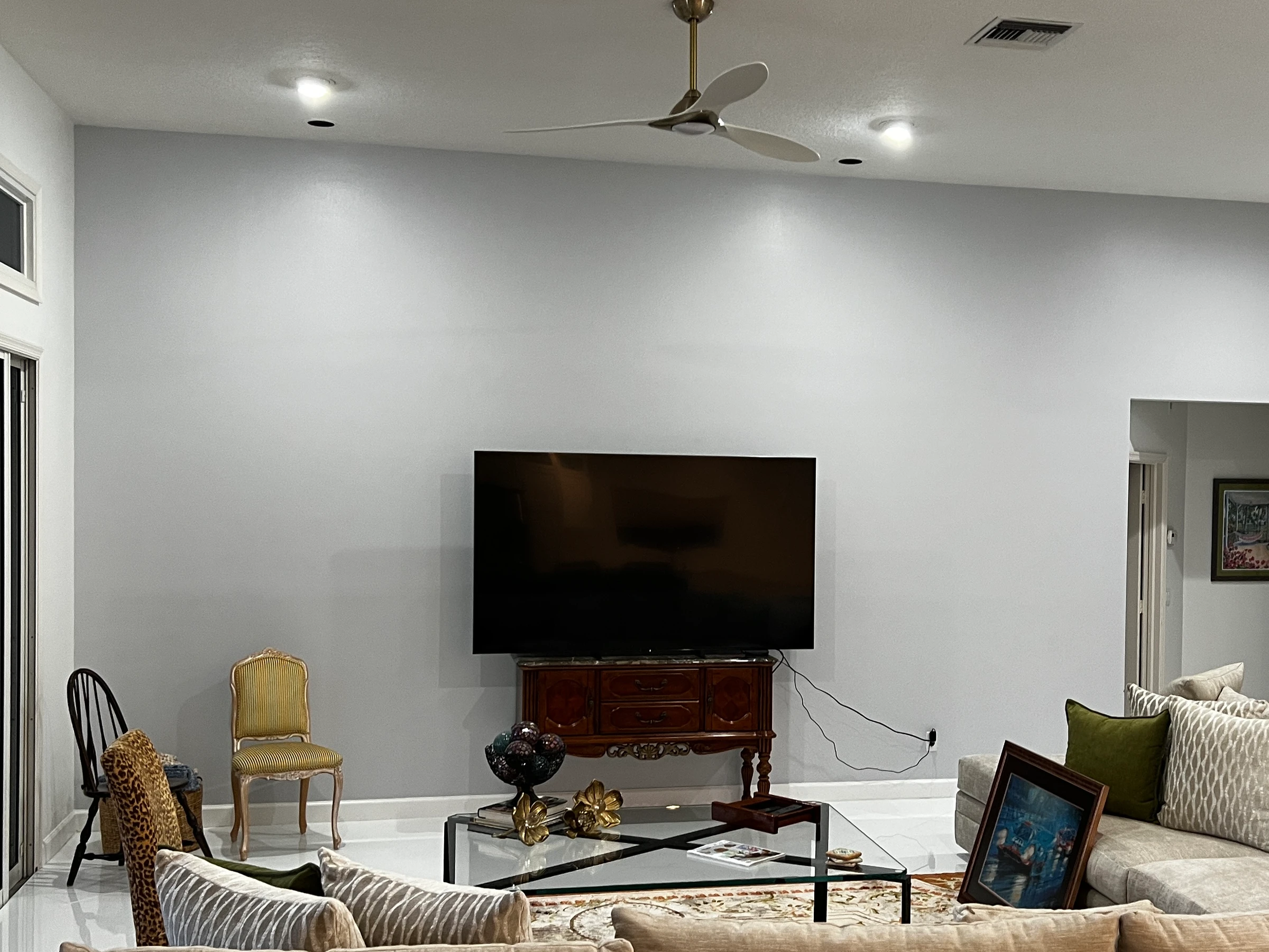 The same living room wall before, with the TV on a small wooden stand