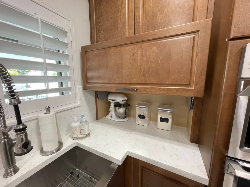 Appliance garage with lift-up door hiding a stand mixer and canisters