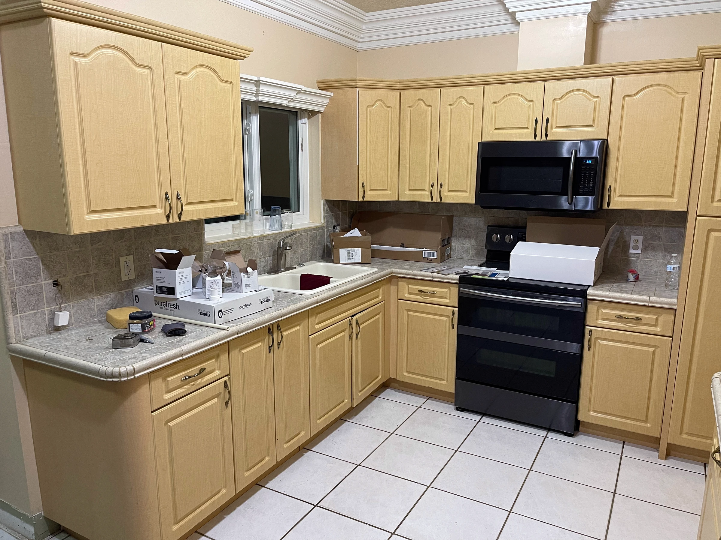 The same wall before the remodel, with light oak cabinets and white tile floor